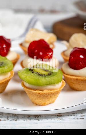 Obsttörtchen. Erdbeer-, Bananen- und Kiwis-Tartlets auf einem Teller. Snack süße Speisen. Nahaufnahme Stockfoto