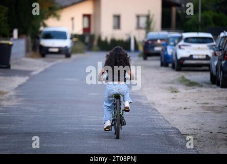 Berlin, Deutschland. September 2023. Sara fährt auf einer Straße in Berlin-Spandau mit dem Fahrrad. Der 12-jährige Gymnasium hat die häufigste Form der rheumatoiden Arthritis bei Kindern (juvenile ideopathische Arthritis). Die Diagnose ist schwierig, besonders bei kleinen Kindern, weil die Symptome sehr unterschiedlich sein können von denen von Erwachsenen. Bei Sara wurde im Alter von 11 Monaten Rheuma diagnostiziert. (Zu dpa 'Sehprobleme, steife Gelenke, oft müde: Tausende von Kindern haben Rheuma') Credit: Bernd von Jutrczenka/dpa/Alamy Live News Stockfoto