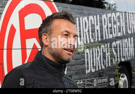 Essen, Deutschland 05. Oktober 2023: Fussball, Herren, 3.Liga, Saison 2023/2024, Rot-Weiss Essen! Achtung Fotomontage! Hier im Bild Christoph Dabrowski, Trainer (Rot-Weiss Essen),im Hintergrund das Logo auf dem Mannschaftsbus Stockfoto