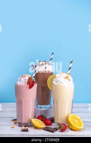 Set aus erfrischenden Sommermilchshakes oder Smoothies mit klassischem, köstlichem Geschmack - Vanille-Zitrone, Erdbeere, Schokolade, mit Schlagsahne und Garnierung, Stockfoto