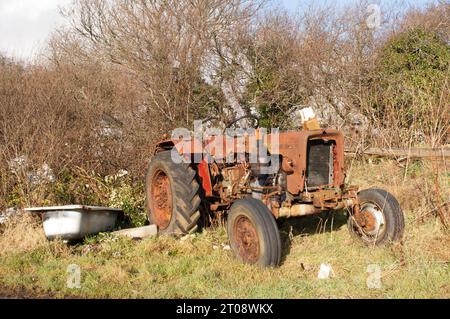 Ein alter rostender Traktor draußen auf dem Feld. Stockfoto