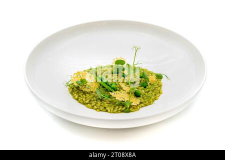 Risotto mit Erbsen auf einer weißen Porzellanplatte auf isoliertem weißem Hintergrund Stockfoto
