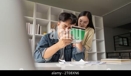 Trauriges Paar, Finanzstress für Steuern, Hypothekarkredit. Finanzieller Verlust, paarweise asiatischer Stress für schlechten Haushaltsplan, Hausversicherungsschulden oder Darlehen Stockfoto