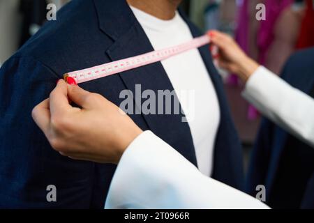 Näherin, die Körpermaße des Kunden im Atelier macht Stockfoto