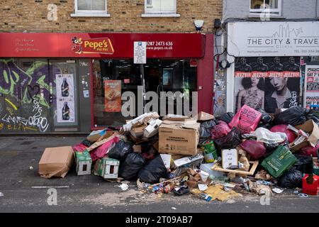 Müll stapelte sich entlang der Brick Lane während eines vierwöchigen Streiks von Mülldienstarbeitern in Tower Hamlets am 25. September 2023 in East London, Großbritannien. Vom 18. September bis zum 1. Oktober streiken die Abfalldienstmitarbeiter und Straßenreinigungskräfte des Tower Hamlets Council. Mehr als 200 Müllarbeiter haben ihre Werkzeuge heruntergestürzt, nachdem sie die Pauschalvergütung um 1.925 £ abgelehnt hatten. Die Arbeitskampfmaßnahme wurde nun um weitere zwei Wochen verlängert, nachdem das Management im laufenden nationalen Lohnstreit kein verbessertes Angebot unterbreitet hatte. Stockfoto