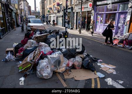 Müll stapelte sich entlang der Brick Lane während eines vierwöchigen Streiks von Mülldienstarbeitern in Tower Hamlets am 25. September 2023 in East London, Großbritannien. Vom 18. September bis zum 1. Oktober streiken die Abfalldienstmitarbeiter und Straßenreinigungskräfte des Tower Hamlets Council. Mehr als 200 Müllarbeiter haben ihre Werkzeuge heruntergestürzt, nachdem sie die Pauschalvergütung um 1.925 £ abgelehnt hatten. Die Arbeitskampfmaßnahme wurde nun um weitere zwei Wochen verlängert, nachdem das Management im laufenden nationalen Lohnstreit kein verbessertes Angebot unterbreitet hatte. Stockfoto