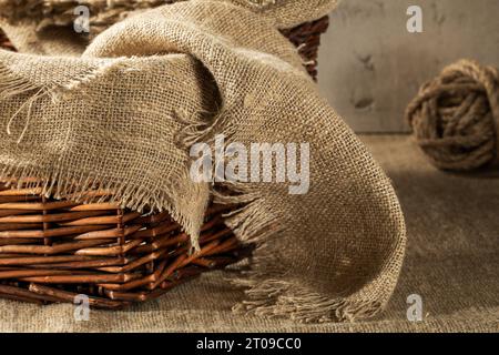 Korb gefüllt mit Sackleinen Servietten aus Nahaufnahme, rustikaler Stil. Stockfoto