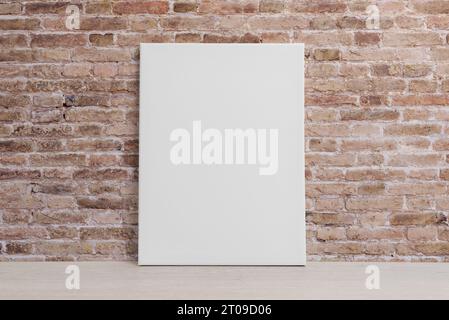 Leere Kunstleinwand, die an die Ziegelwand gelehnt ist. Saubere Oberfläche für Mockup und Kunstpräsentation Stockfoto