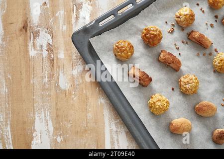 Blick von oben auf die süßen panellets, die auf einem Tablett auf einem Holztisch serviert werden Stockfoto