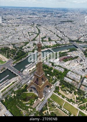 Von oben aus haben Sie einen malerischen Blick auf den berühmten Eiffelturm, der sich auf einem grünen Hügel vor bewölktem Himmel in Paris befindet Stockfoto