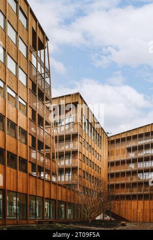 Flacher Blick auf das Äußere eines großen braunen Wohngebäudes vor dem bewölkten Himmel in der Stadt Stockfoto