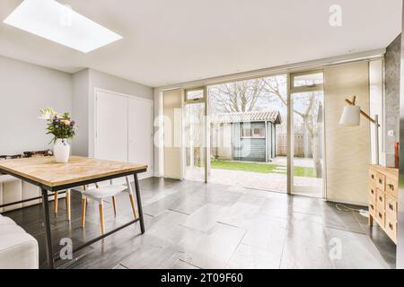 Das Innere des geräumigen Esszimmers mit Tisch und Stühlen vor der Tür führt zum Hinterhof Stockfoto