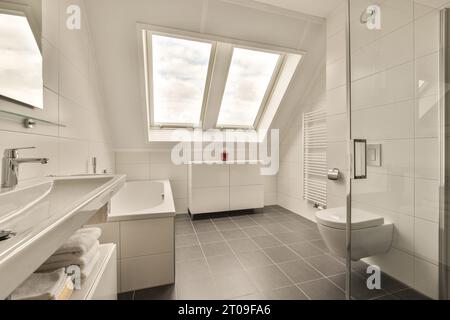 Innen großes, modernes Badezimmer mit Waschbecken und Badewanne durch Toilettensitz im Vorderfenster zu Hause Stockfoto