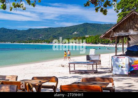 Ein Paar spaziert auf Sand in einer Landschaft mit Meer und Sand am Chaweng Beach, Ko Samui, Thailand Stockfoto