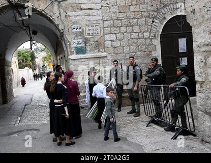 Altstadt Jerusalem, Israel. Oktober 2023. Israelische Grenzpolizisten stehen vor orthodoxen Juden, die in der Nähe eines Eingangs zum Tempelberg oder Al Aqsa Compound im muslimischen Viertel der Altstadt von Jerusalem beten, während des jüdischen Festes von Sukkot, dem Tabernakelfest, am Donnerstag, den 5. Oktober 2023. Foto: Debbie Hill/ Credit: UPI/Alamy Live News Stockfoto