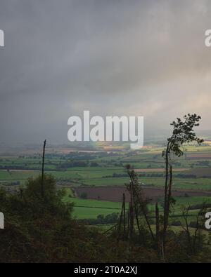 Regenbogen über Simonside Hills und Felsen. Blick auf die Cheviots. Northumberland. Stockfoto