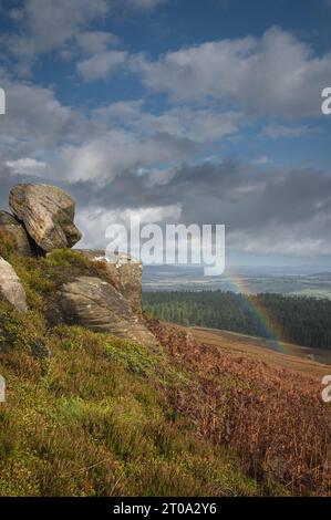 Regenbogen über Simonside Hills und Felsen. Blick auf die Cheviots. Northumberland. Stockfoto