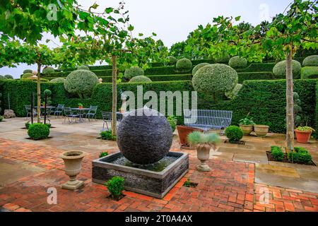 Die sorgfältig und ordentlich geformten Birnen- und Eibenhecken in den Gärten des Old Hall Hotels in der Nähe von Ely, Cambridgeshire, England, Großbritannien Stockfoto