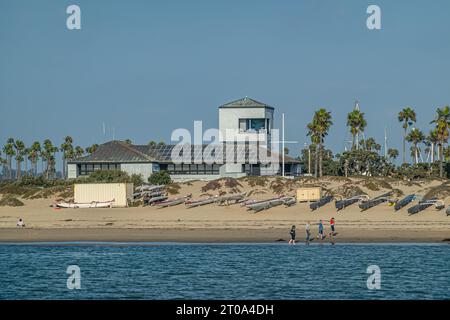 Ventura, CA, USA - 14. September 2023: Hafengebäude am Ende des Spinnaker Drive mit turmähnlichem Anbau. Hinter Sandstrand mit Menschen und Dose gesehen Stockfoto