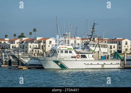 Ventura, CA, USA - 14. September 2023: Die Boote des National Park Service legten vor roten Häusern unter blauem Himmel im Hafen an Stockfoto