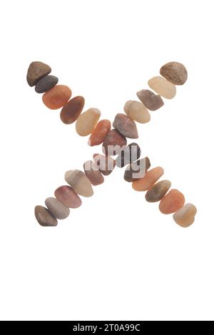 X handgefertigte Schriftart aus Steinen, Zeichen der Natur, Stärke, Stabilität und Langlebigkeit. Auffällige zufällige Muster, Linien, Formen, weißer Hintergrund Stockfoto