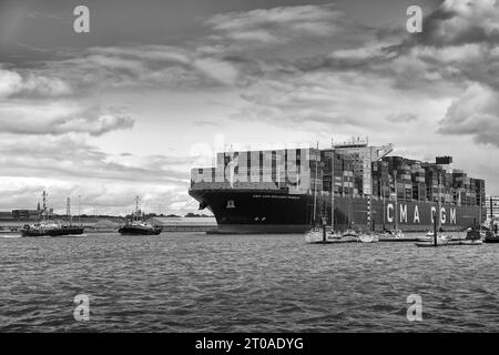 Schwarzweiß-Foto des ultragroßen Containerschiffs CMA CGM Benjamin Franklin, der durch den Deep Water Channel im Hafen von Southampton fährt Stockfoto