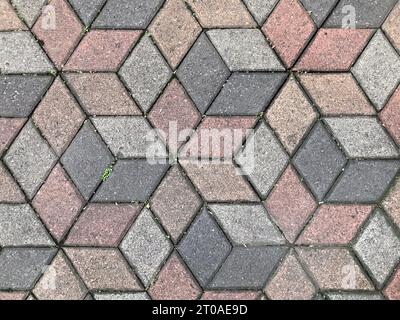 Nahtlose Pflastersteinstruktur im sechseckigen geometrischen Würfelmuster. Dunkelgrau, rosa und grau. Hintergrund der Pflasterstruktur. Querformat Stockfoto