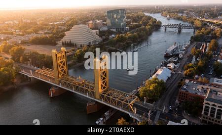 Blick bei Sonnenuntergang auf die historische Tower Bridge von 1935 und die Skyline der Innenstadt von Old Sacramento, Kalifornien, USA. Stockfoto