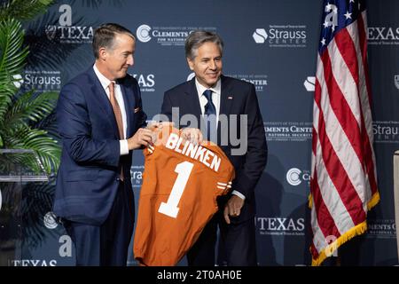 Austin Texas USA, 4. Oktober 2023: US-Außenminister ANTONY BLINKEN (rechts) erhält ein Fußballtrikot von der University of Texas at Austin Präsident JAY HARTZELL (links), nachdem Blinken eine außenpolitische Diskussion im Hogg Auditorium der University of Texas geführt hatte. ©Bob Daemmrich Stockfoto