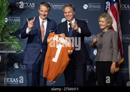 Austin Texas USA, 4. Oktober 2023: US-Außenminister ANTONY BLINKEN (Mitte) erhält ein Fußballtrikot von der University of Texas at Austin Präsident JAY HARTZELL (links), während KAY BAILEY HUTCHISON zusieht. Blinken leitete eine außenpolitische Diskussion am Hogg Auditorium der University of Texas. Die drei blinken das Handsignal der Universität von Texas. ©Bob Daemmrich Stockfoto