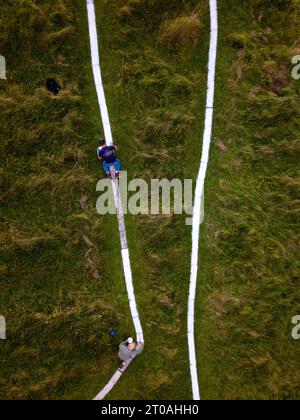 Der lange Mann von Wilmington bekommt einen Leck Farbe. Die in die South Downs geschnitzte Chaklk-Figur wird bei ihrer fünfjährlichen Lackierung überarbeitet. Freiwillige, Stockfoto