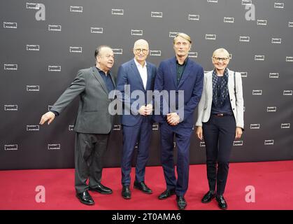 Hamburg, Deutschland. Oktober 2023. Schauspieler Mads Mikkelsen (2. Von rechts) steht mit Festivaldirektor Albert Wiederspiel (l) und Peter Tschentscher (SPD), 1. Bürgermeister und Präsident des Senats der Freien und Hansestadt Hamburg, mit Frau Eva-Maria Tschentscher auf dem Roten Teppich im Cinemaxx anlässlich der Premiere des Films „Königsland“. Quelle: Marcus Brandt/dpa/Alamy Live News Stockfoto