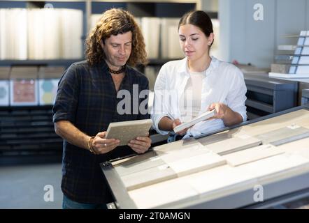 Ehemann und Ehefrau wählen Keramikfliesen für die Inneneinrichtung im Baumarkt Stockfoto