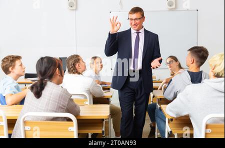 Männlicher Lehrer, der mit interessierten Teenagern Unterricht gibt Stockfoto