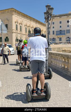 Valletta, Malta - 3. August 2023: Gruppe von Besuchern der Stadt, die auf selbstausbalancierenden Elektrofahrzeugen unterwegs sind, um die Stadt zu erkunden. Stockfoto