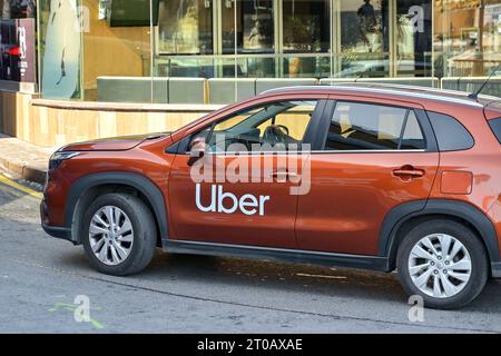 St. Julians, Malta - 3. August 2023: Uber Taxi fährt eine Straße im Zentrum von St. Julians entlang Stockfoto