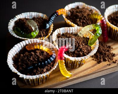 Halloween-Cupcakes dekoriert mit Gelee-Würmern, selektiver Fokus. Lustiges und gruseliges Essen für Kinder und Erwachsene Stockfoto