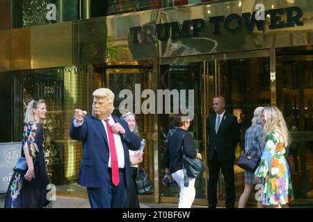 New York, USA. Oktober 2023. Ein Imitator, der eine Maske des ehemaligen US-Präsidenten Donald Trump trägt, tritt für Passanten am Haupteingang des Trump Tower in der Fifth Avenue in Midtwown Manhattan auf. Trump steht derzeit vor einem Zivilverfahren in New York. Quelle: Enrique Shore/Alamy Live News Stockfoto