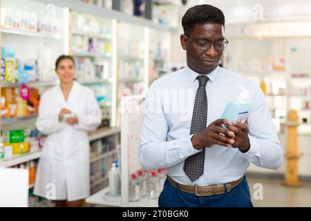 Mann hält Flasche mit Haarpflegeprodukt Stockfoto