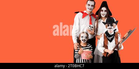 Glückliche Familie, die zu Halloween auf orangefarbenem Hintergrund gekleidet ist, mit Platz für Text Stockfoto