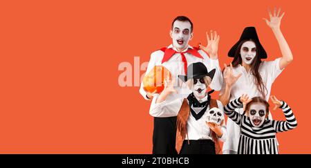 Glückliche Familie, die zu Halloween auf orangefarbenem Hintergrund gekleidet ist, mit Platz für Text Stockfoto