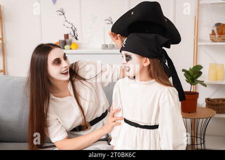 Glückliche Mutter mit ihren kleinen Kindern, die zu Hause Halloween feiern Stockfoto