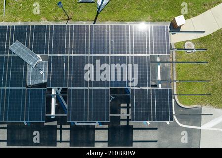 Ausfall der Photovoltaik-Technologie, die in die städtische Infrastruktur integriert ist. Hurrikan-Windschäden an Solarpaneelen, die als Schattendach über dem Parkplatz installiert sind Stockfoto