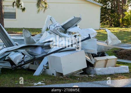 Müllhaufen auf der Straßenseite von stark beschädigten Häusern nach dem Hurrikan in Florida Wohnmobilgebiet. Folgen von Naturkatastrophen Stockfoto