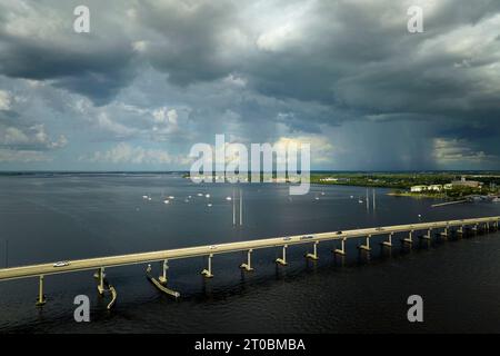 Stürmische Wolken, die sich aus der verdampfenden Feuchtigkeit des Meerwassers bilden, bevor es über die Verkehrsbrücke zwischen Punta Gorda und Port Charlotte donnert Stockfoto