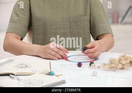 Astrologe mit Zodiakrad und Würfeln für die Schicksalsvorhersage am Tisch, Nahaufnahme. Glücksbringer Stockfoto