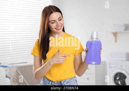 Schöne Frau, die im Badezimmer einen Weichspüler zeigt Stockfoto