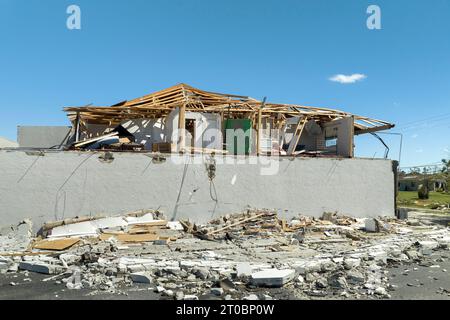 Der Wind zerstörte das Hausdach und die Wände mit fehlenden Asphaltschindeln nach dem Hurrikan Ian in Florida. Abriss von Gebäuden nach Naturkatastrophen Stockfoto