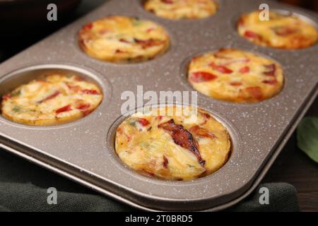 Frisch gebackener Speck und Eiermuffins mit Käse in der Dose auf dem Tisch, Nahaufnahme Stockfoto