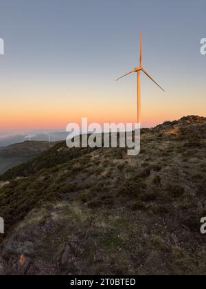 Windturbinen steigen während des Mondes über einem Hügel in Arouca, Portugal. Stockfoto